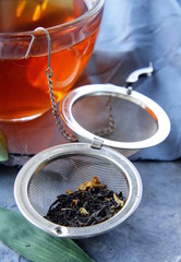 tea strainer with a fragrant black tea and cups