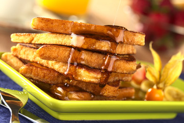 Pouring maple syrup on French toast