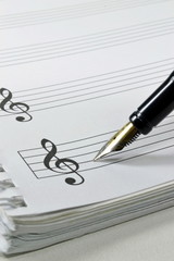 A fountain pen on a book of blank sheet music