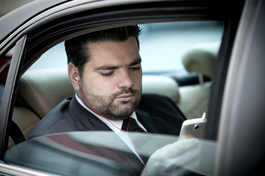 Businessman  listening to music on his phone