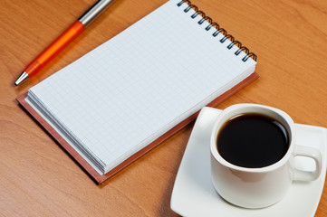 Notebook on table and coffee.