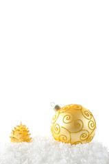 a gold ball and cande on snow