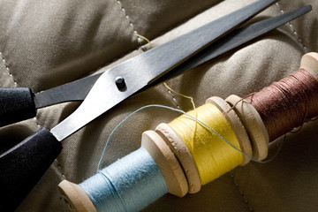 Thread bobbins with scissors on a gray fabric