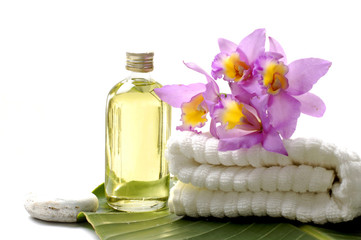 Obraz na płótnie Canvas Fresh Orchid i ręcznik z oleju masażu na liściu bananowca w Spa