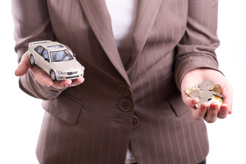 Woman's hand holding the model of car and coins