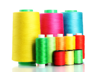 Many-coloured bobbins of thread isolated on white