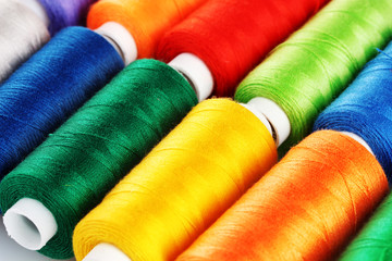 Many-coloured bobbins of thread closeup