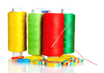 Many bobbin of thread with needle and buttons isolated on white