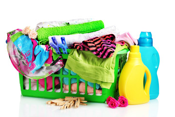 Clothes with detergent and in green plastic basket isolated