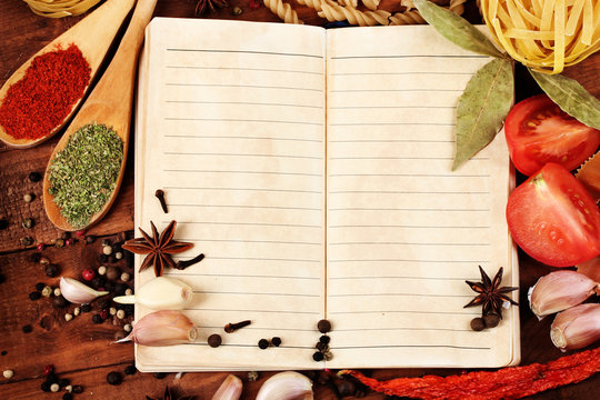 notebook for recipes and spices on wooden table