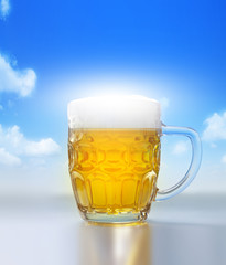 Cold beer in glass on blue sky background