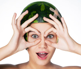 Fancy young girl with watermelon as a helmet on her head