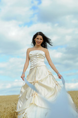 Fototapeta na wymiar Beautiful bride in a field with ribbons