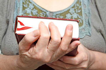 Human hands holding a book.