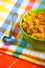 Delicious breakfast corn flakes in green bowl