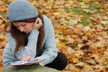 A young girl with a book in the park