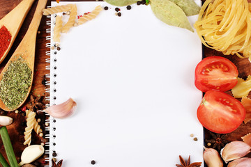 notebook for recipes and spices on wooden table