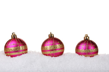 beautiful pink Christmas balls in snow isolated on white