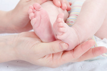 Obraz na płótnie Canvas Mother's hands holding baby's feet