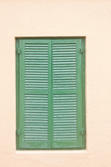 Green Shutter in Pink Stucco Wall