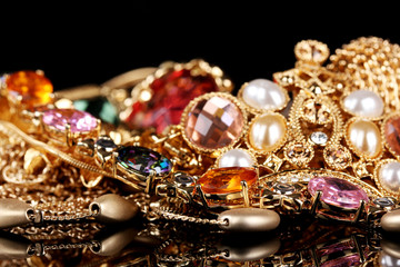 Various gold jewellery on black background