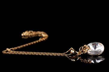 beautiful gold necklace with gem on black background