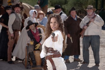 Fototapeta na wymiar Defiant cowgirl pointing gun.