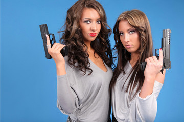 Two beautiful women with pistols.