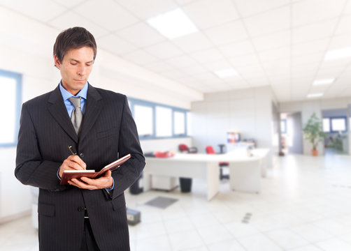 Businessman writing on his agenda