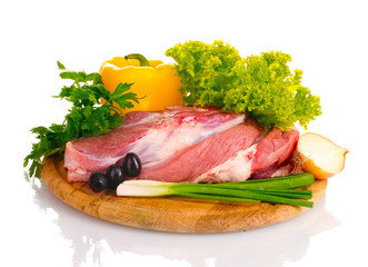 Raw meat and vegetables on a wooden board isolated on whitе