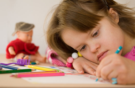 Close up of a girl with Down syndrome drawing.