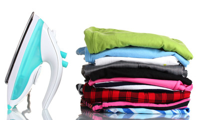 Pile of colorful clothes and electric iron isolated on white