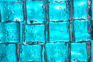 Melting ice cubes on blue closeup