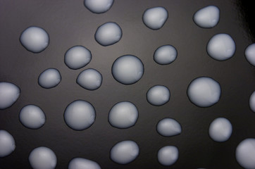 Textura de gotas de leche sobre fondo negro.