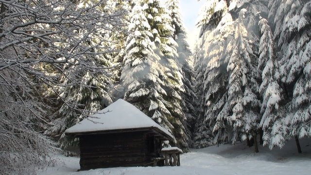 log cabin in snow with smoke and trees