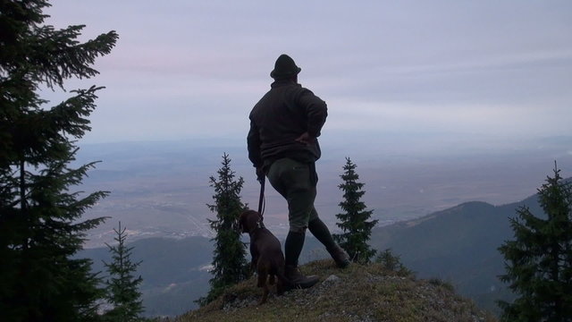 hunter with his dog on a rock