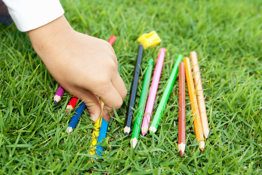 Детская рука выбирает цветной карандаш
