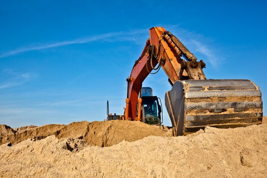 Excavator during earth moving works outdoors at sand quarry