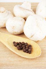 Fresh mushrooms with spoon of pepper