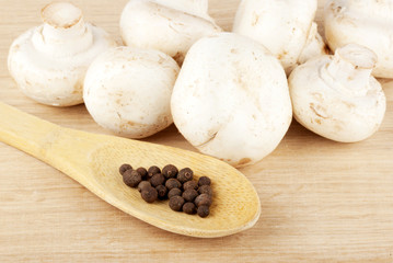 Fresh mushrooms with spoon of pepper
