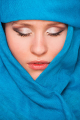 young beautiful girl with closed eyes in blue scarf