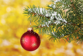 Christmas ball on the tree on yellow