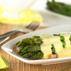 Cooked green asparagus on bacon with Hollandaise sauce