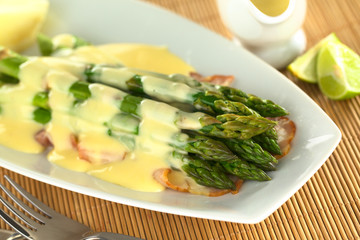 Cooked green asparagus on bacon with Hollandaise sauce