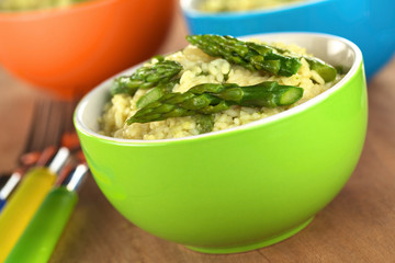 Green asparagus risotto in colorful bowls