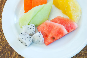 Mixed fruit in the dish on wood texture