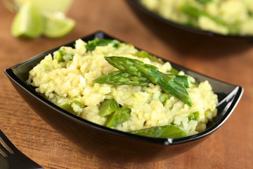 Green asparagus risotto in black bowl
