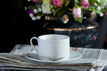 Coffee cup with flower and newspaper