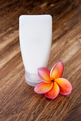Tropical Frangipani and Toiletries on wooden table for spa and w