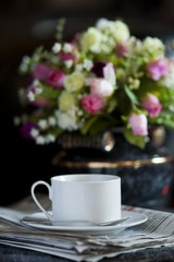 Coffee cup with flower and newspaper